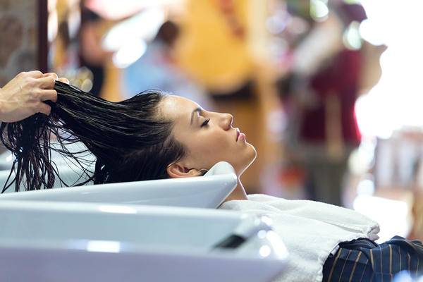 Tretman se završava na kosi devojke nad šamponjerom